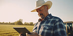 Farmer with digital tablet checking sustainable farming growth.