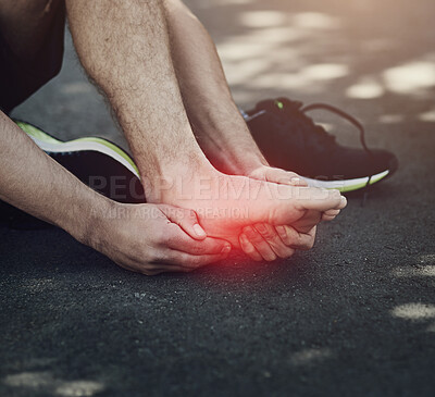 Buy stock photo Cropped shot of an unrecognizable man suffering with foot cramp during a run