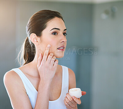 Buy stock photo Woman, face and beauty cream for skin care in home bathroom for health, glow and wellness. Female model person with a product container for dermatology, cosmetics and healthy facial or sunscreen