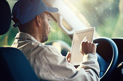 Buy stock photo Cropped shot of a delivery man using a digital tablet while sitting in his van