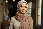 Portrait of muslim woman posing in home. Wearing hijab. Religion concept.