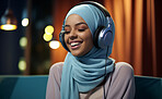 Portrait of young muslim woman smiling with headphones. Wearing hijab.Religion concept.