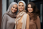Three happy muslim women friends posing. Wearing hijab. Religion concept.