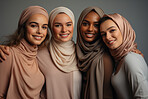 Four happy muslim women posing on Studio backdrop. Wearing hijab. Religion concept.