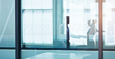 Buy stock photo Shot of two colleagues shaking hands in the boardroom