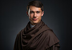 Studio portrait of young priest. Wearing monk robe. Natural smile. Religion concept.