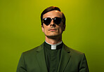 Studio portrait of young  priest wearing glasses. Vibrant colour. Religion concept.