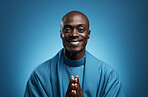Studio portrait of african priest against blue backdrop. Religion concept.