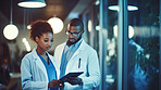 Portrait of male and female African American doctors looking at a tablet