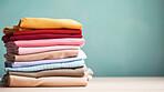 Stack of colorful folded clothing items. Clean laundry copyspace background