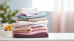 Stack of colorful folded clothing items. Clean laundry copyspace background