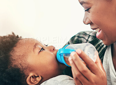 Buy stock photo Shot of a mother giving her little baby boy a bottle