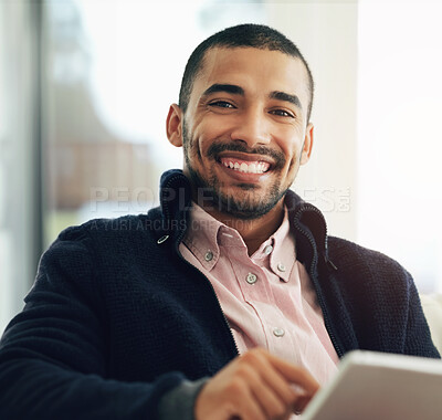 Buy stock photo Portrait of a smiling young man working at home on a digital tablet