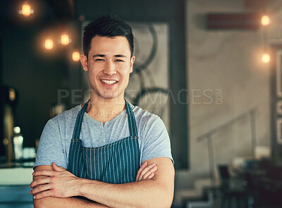 Buy stock photo Cropped portrait of a young man standing with his arms folded in his coffee shop
