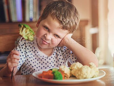 Buy stock photo Portrait of a disgusted little boy refusing to eat his vegetables at the dinner table