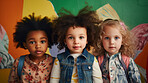 Portrait of diverse toddlers posing against a colorful wall at kindergarten or preschool