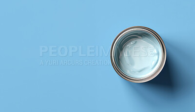 Top view of open can of paint on blue backdrop. Copy space. Construction concept.