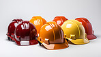 Studio shot of multi-colour hard hats on clear backdrop.
Construction, labour day concept.