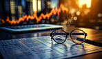 Glasses on table  with financial documents. City background. Stock market concept.