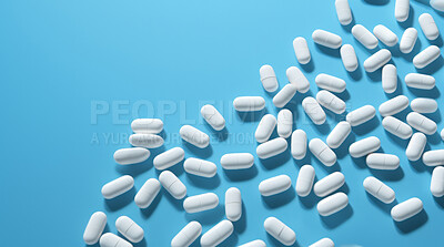 White pills on blue background. Health supplement and science medicine research concept