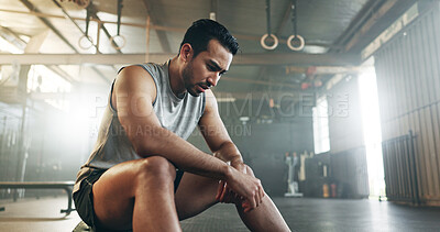 Tired, breathing and fitness gym man taking a break from workout, training  or exercising inside a wellness center. Young athletic, masculine guy  resting after his strength or muscle exercise session Stock Photo