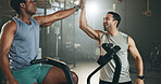 Man, cycling and personal trainer in high five, motivation or fitness workout, exercise and training at gym. Trainer coaching male person on bicycle, machine or equipment in cardio at health club