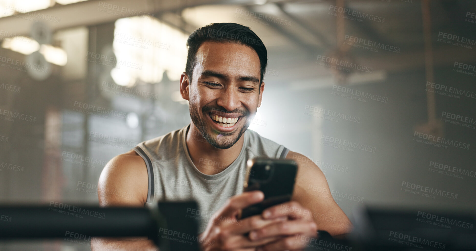 Buy stock photo Happy asian man, phone and fitness on break in social media, communication or networking at gym. Active male person smile for online texting or chatting on mobile smartphone app at indoor health club