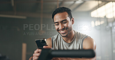 Happy asian man, phone and fitness on break in social media, communication or networking at gym. Active male person smile for online texting or chatting on mobile smartphone app at indoor health club