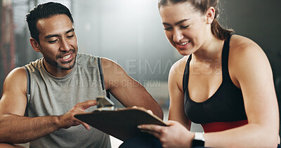 Man, woman and clipboard with writing in gym, sign up and planning for ideas, workout and smile with info. Personal trainer, paperwork and signature for fitness, checklist or agreement for wellness
