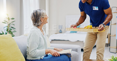 Breakfast, assisted living and retirement with a mature woman on a sofa in the living room of her home. Morning, food and a nurse black man serving a meal to an elderly patient in a care facility