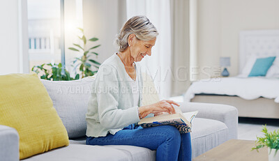 Senior woman, book and reading to relax in living room for story, novel and knowledge. Elderly female person, books and focus in lounge for retirement break, literature and hobby on sofa at home
