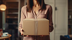 Young woman carrying large box during a move to new home or package delivery