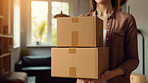 Young woman carrying large box during a move to new home or package delivery