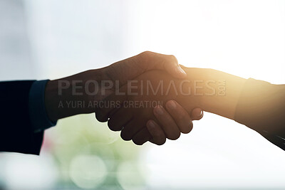 Buy stock photo Cropped shot of two silhouetted businesspeople shaking hands in the office
