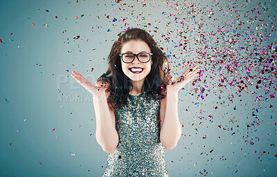 Buy stock photo Studio shot of a young woman with confetti falling around her against a grey background
