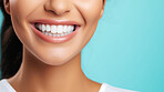 Closeup of woman with a beautiful smile for dental care against a blue background