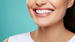 Closeup of woman with a beautiful smile for dental care against a blue background