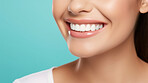 Closeup of woman with a beautiful smile for dental care against a blue background