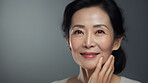 Radiant mature senior model woman smiling for spa beauty and skincare in studio