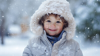 Toddler boy wearing a coat, playing in the winter snow during the holiday season