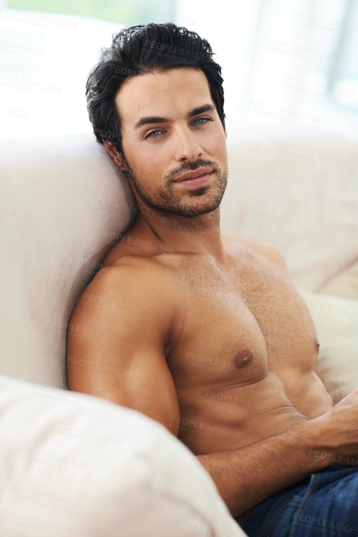 Buy stock photo Portrait of a bare-chested young man sitting on a sofa