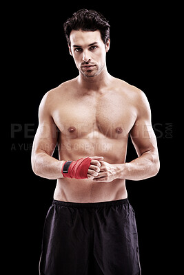 Buy stock photo Studio portrait of a fit young man with wrapped fists isolated on black
