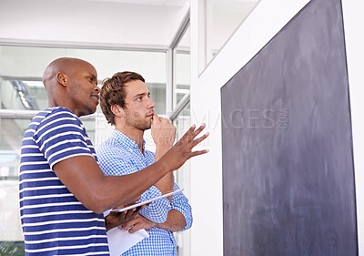 Buy stock photo Shot of two designers working at a chalkboard