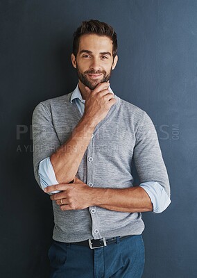 Buy stock photo Portrait of a handsome young businessman posing against a dark background