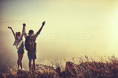 Buy stock photo Rearview shot of an unidentifiable young couple admiring the view from a mountain peak together