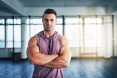 Buy stock photo Portrait of a muscular young man listening to music at the gym