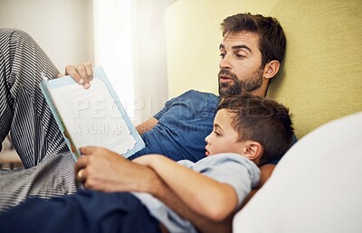 Buy stock photo Family, father and son with a book, home or reading with bonding, development and relax in a bedroom. Happy parent, male child or kid with dad, literature and learning on a bed, love and storytelling