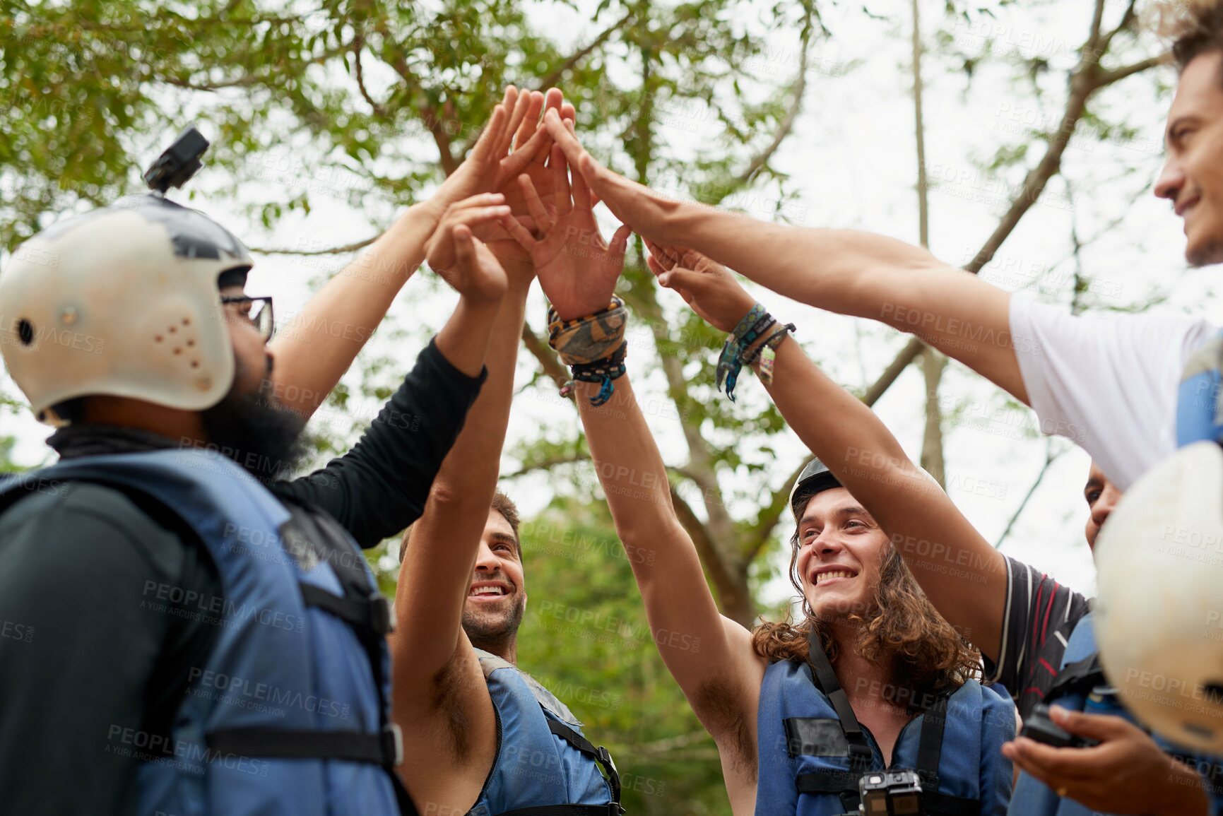 Buy stock photo Cropped shot of a group of young male friends giving each other a high five before they go white water rafting