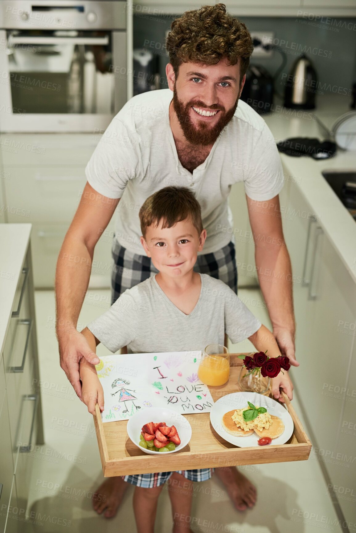 Buy stock photo Shot of an adorable little boy holding a tray of breakfast with his father for Mother's Day