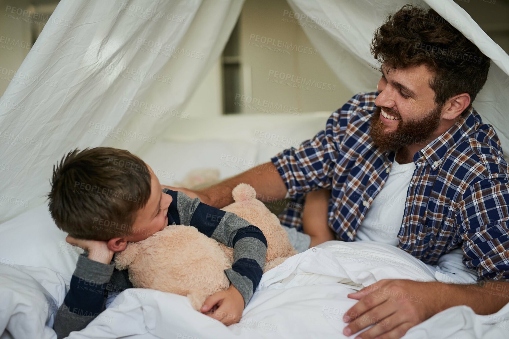 Buy stock photo Cropped shot of a handsome young man and his son bonding on the bed at home